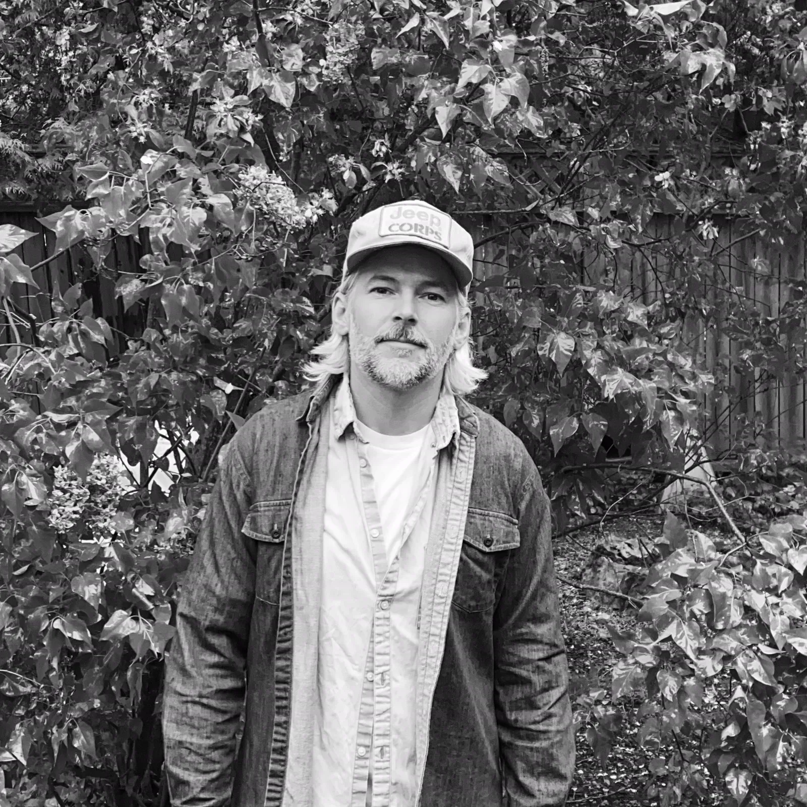 Lee Watson standing outdoors in a black and white portrait.